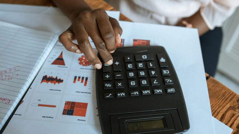 Desk calculator and financial documents — government budget and cost analysis planning for electronic monitoring procurement (stock image, Pexels)