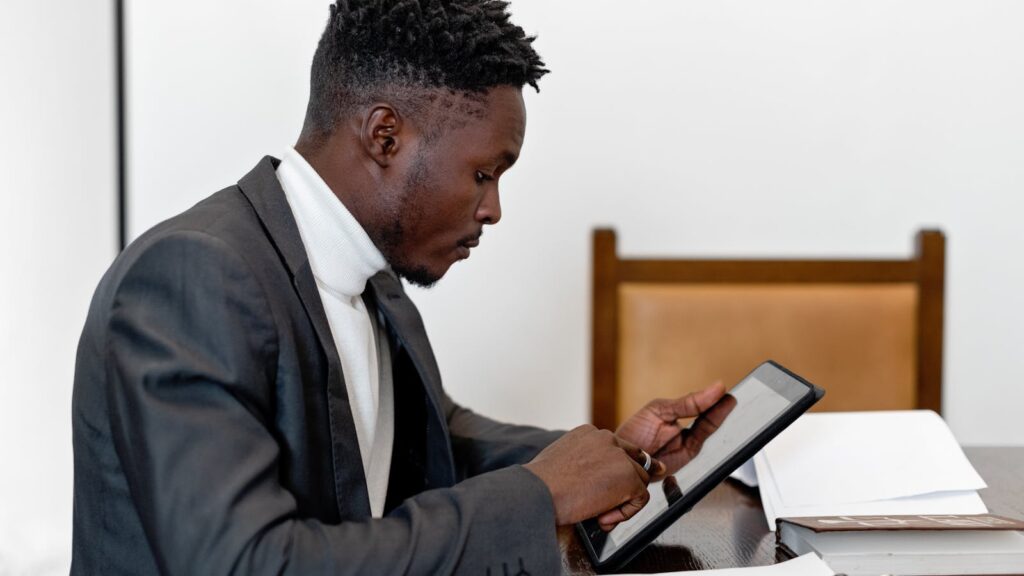 Professional supervisor reviewing documents and data on a tablet — digital workflow for GPS ankle bracelet fleet maintenance and electronic monitoring operations