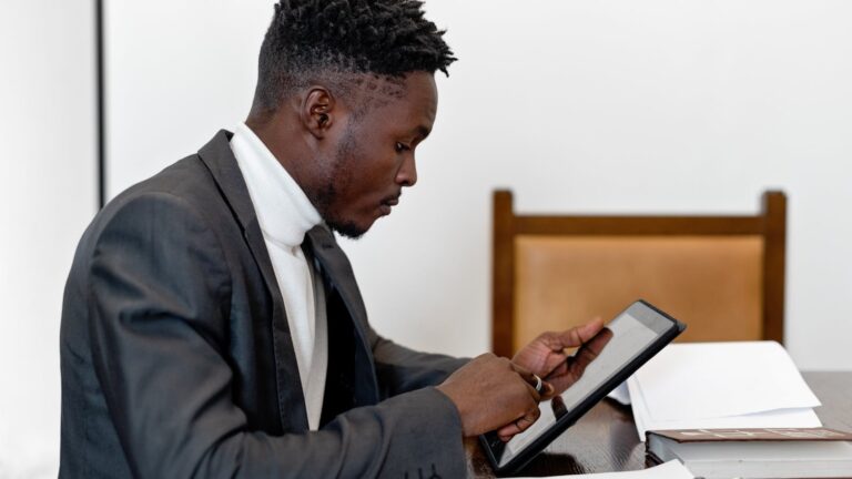 Professional supervisor reviewing documents and data on a tablet — digital workflow for GPS ankle bracelet fleet maintenance and electronic monitoring operations