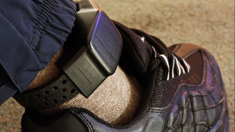 UK GPS ankle tag electronic monitoring device worn by offenders for 24/7 location tracking and restriction zone compliance